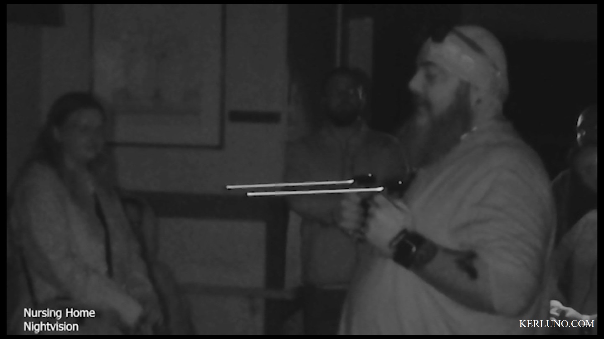 Middle-aged guy on right holding two small hand-held rods